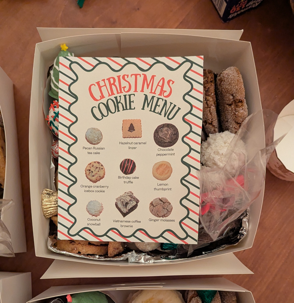 A card reading "Christmas cookie menu" in red and green type atop one of the boxes. It has photos of each of the cookies to identify them