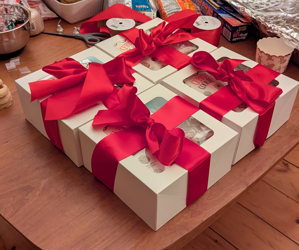 Four cookie boxes wrapped in large red ribbons