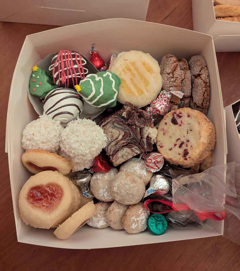 A box filled with a variety of all the cookies, with Hershey's kisses scattered throughout