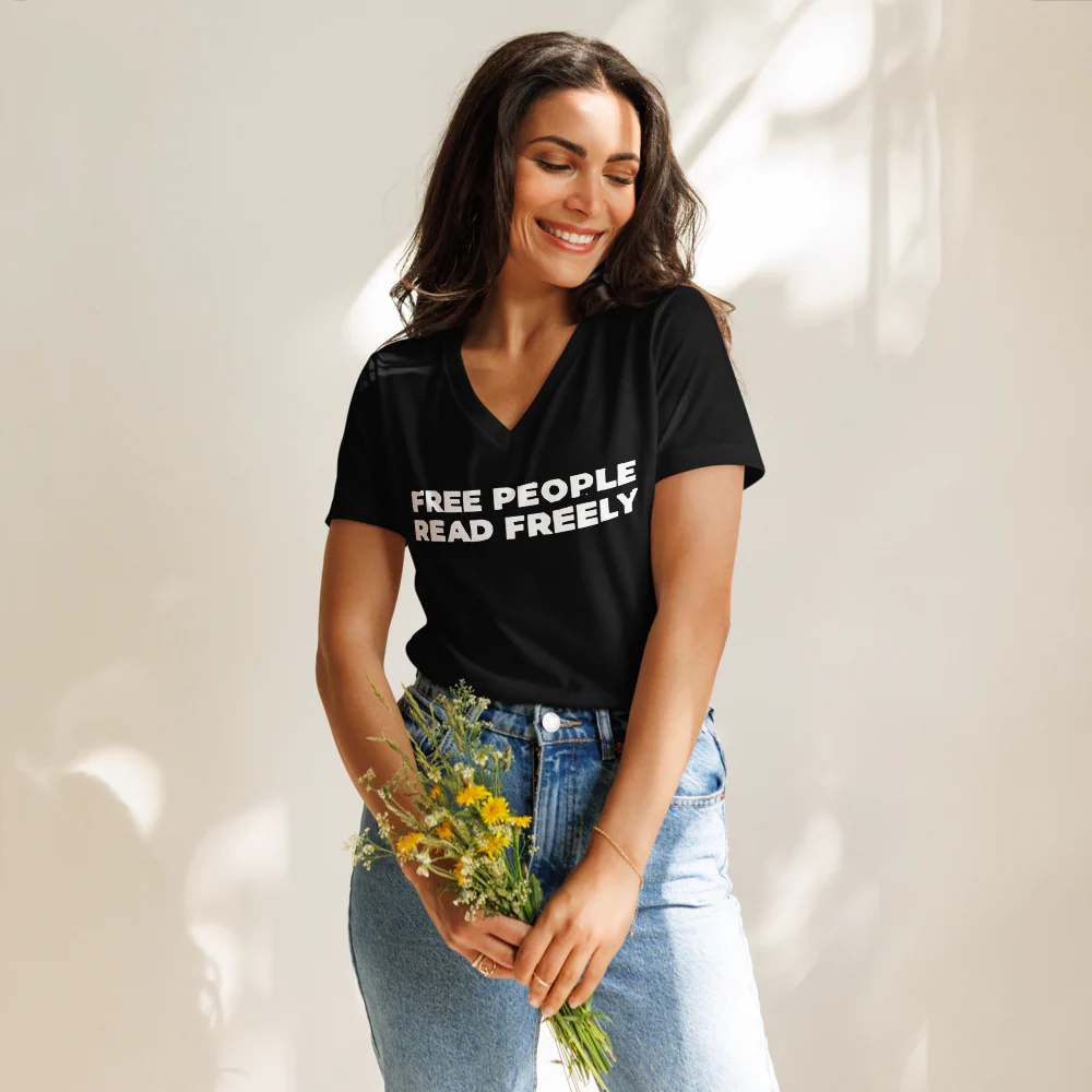 A black v-neck t-shirt featuring the linocut-carved text “free people read freely”